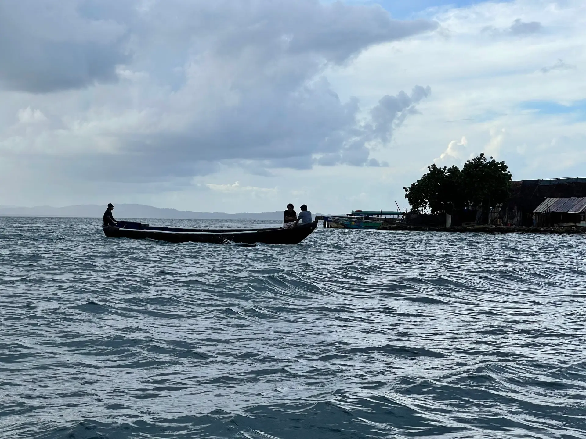Small motorized canoe traveling between the San Blas Islands, carrying locals going about their daily lives.
