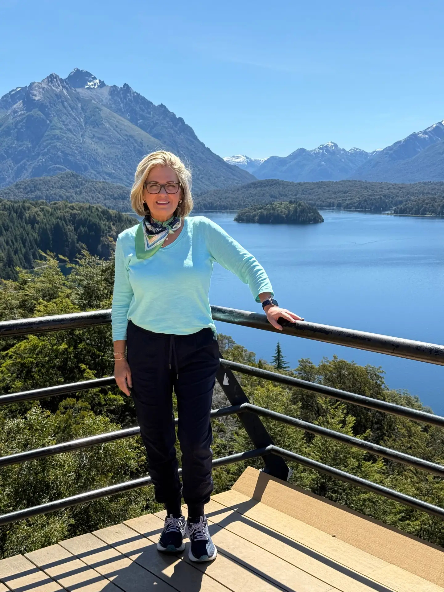 The author posing at an overlook of one of the seven lakes of Bariloche with mountains in the background.