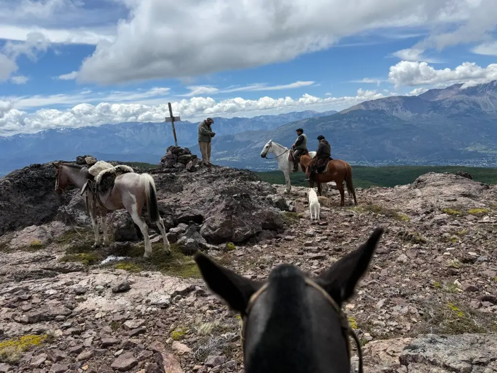 Four horseback riders visiting a cross in Argentina's Patagonian Region, the New Old West